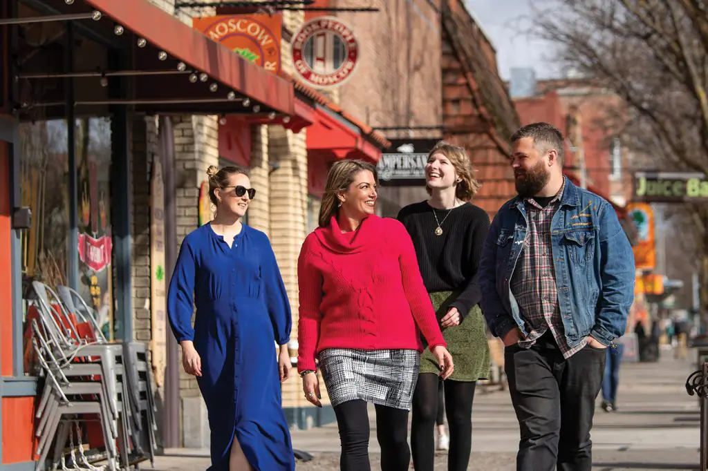 Group of people walking on shop lined sidewalk in Moscow, Idaho
