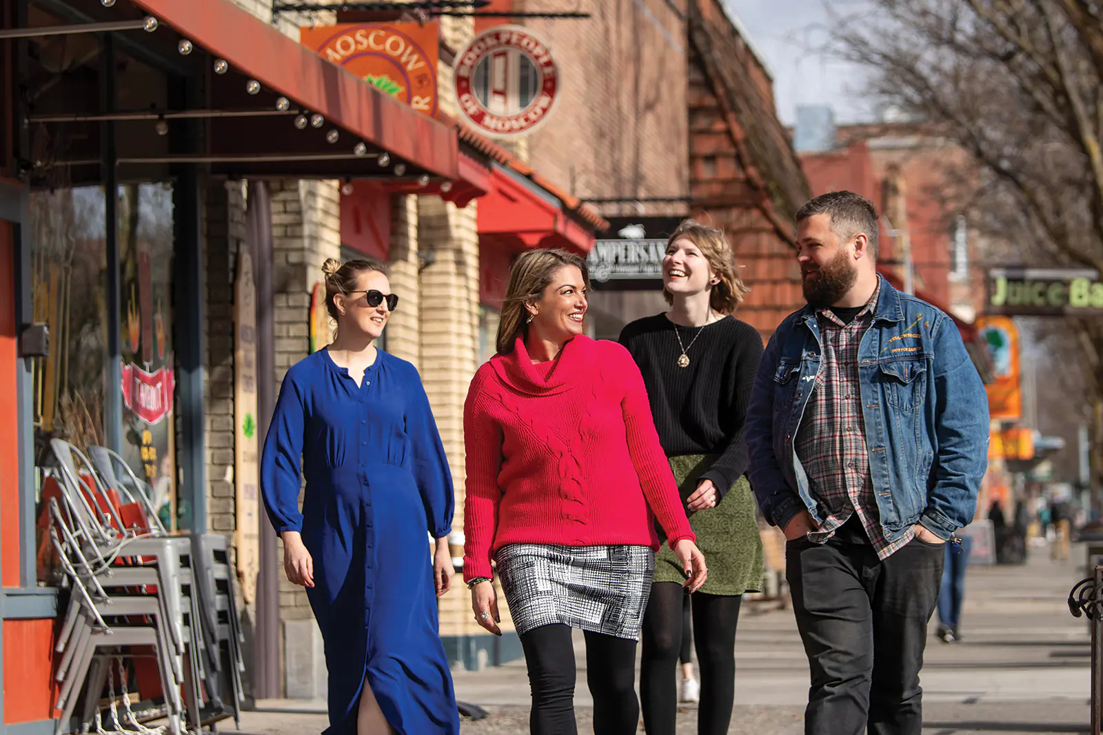 Group of people walking on shop lined sidewalk in Moscow, Idaho